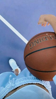 a person holding a basketball on top of a blue court with the words dancet written on it