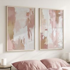 two paintings hang on the wall above a bed with pink sheets and pillows, next to a night stand