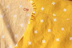 two pieces of yellow fabric with white flowers on them and the words clip written in red