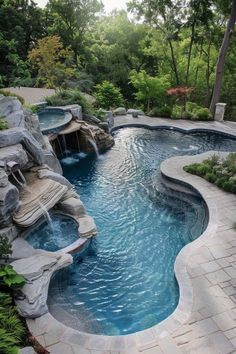 an outdoor swimming pool surrounded by stone steps and water features is shown in this landscaped backyard