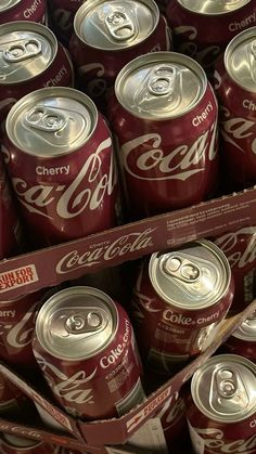 many cans of coca - cola are stacked on top of each other