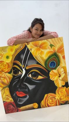 a woman is holding up a painting with flowers and a peacock on it's head