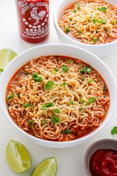 two white bowls filled with noodles and garnished with cilantro