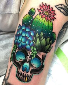 a skull with a cactus and flower on it's head