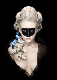 a woman wearing a black mask and long blonde hair