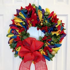 a red and yellow christmas wreath on a white door