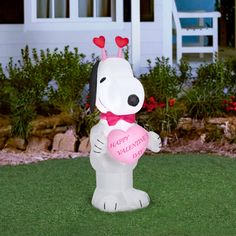 a large inflatable dog holding a heart shaped balloon