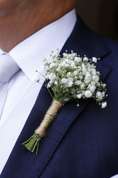 a man wearing a suit and tie with a boutonniere on his lapel