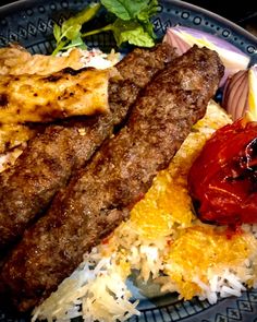 a blue plate topped with meat, rice and veggies