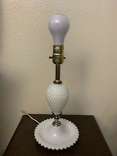 a white lamp sitting on top of a wooden table