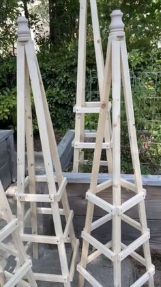 three wooden ladders sitting next to each other in front of some bushes and trees