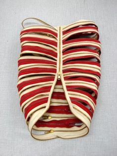 a red and white purse with multiple straps