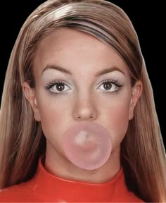 a woman with long blonde hair blowing a bubble on her nose while wearing a red shirt