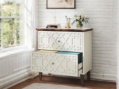 a white cabinet with two drawers in front of a window and a rug on the floor