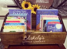 there are many books on display in the wooden box with sunflowers and i love you daddy sign