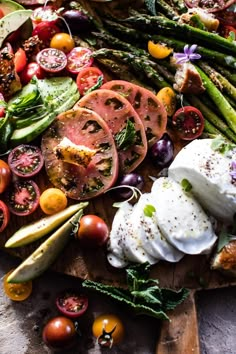 a wooden cutting board topped with lots of veggies and sauce on top of it