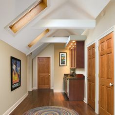 a hallway with hardwood floors and white walls, has a rug on the wooden floor