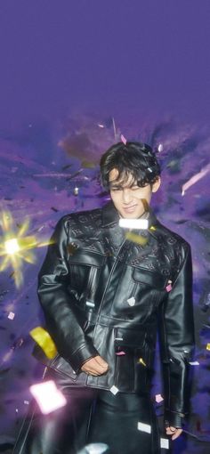 a man in black leather jacket and white shirt standing next to a purple background with confetti