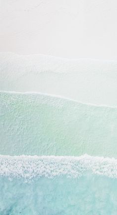 two surfers are riding the waves on their surfboards in the blue green water