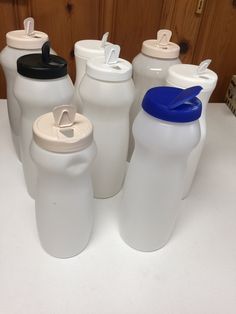 six white plastic water bottles lined up on a counter