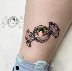 a woman's leg with a fish tattoo on her left thigh and an eyeball in the middle