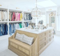 a large closet filled with lots of clothes and other items in it's center island