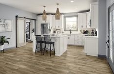 a kitchen with white cabinets and wooden floors