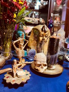 a table topped with vases filled with flowers and skulls