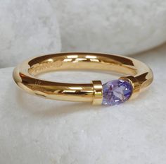 A gorgeous Tanzanite precious gemstone in a tension set gold ring. This beautifully polished gold, hallmarked ring has been hand made in our Leeds, UK studio. Only discovered as recently as 1967 near Mount Kilimanjaro, the Tanzanite is quite a unique and rare stone. It comes in a variety of colours, and violet/blue is the most sought after. Tension Ring, Leeds Uk, Tension Setting, Unusual Rings, Rare Stone, Tanzanite Ring, Aquamarine Ring, March Birthstone, Aquamarine Rings