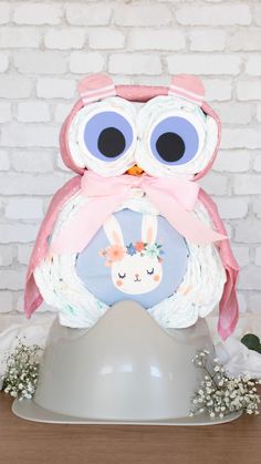 an owl cake sitting on top of a white platter with flowers and greenery