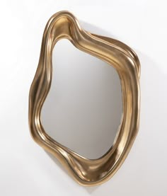 a mirror that is on the wall in front of a white background with an interesting shape