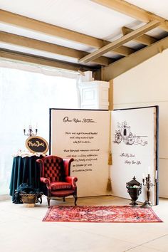 a room with a red chair and an open book on the floor