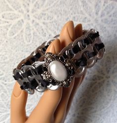 a doll's hand is holding several bracelets