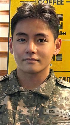 a man in uniform standing next to a yellow sign