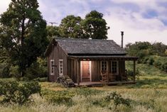 a small wooden cabin sitting in the middle of a field