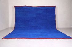 a blue rug with red border in an empty room