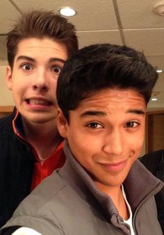 three young men taking a selfie in an office building, one with his head tilted to the side