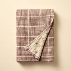 a pink and white checkered blanket folded on top of a wall