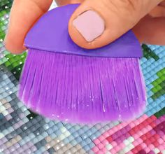 a person holding a purple brush in their hand