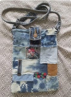 a handbag made out of old jeans with patches and flowers on the front pocket