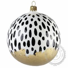 a white and black polka dot ornament with gold trimmings on it