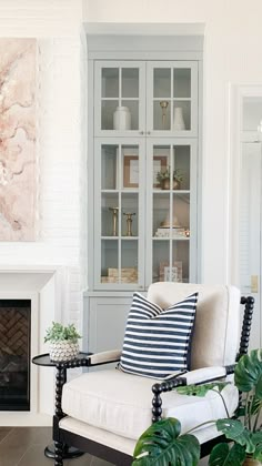 a living room filled with furniture and a fire place in front of a white brick wall