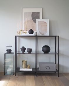 a shelf with vases and other items on top of it in a living room