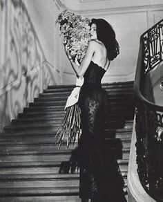 a woman is walking down some stairs with flowers