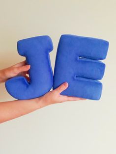 a person holding two blue objects in their hands with the letters e and f on them