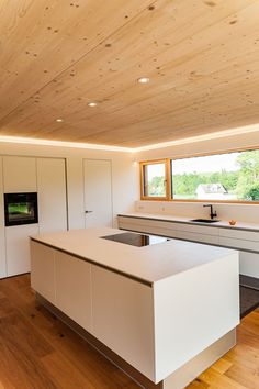 a kitchen with white counters and wooden ceiling