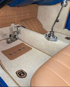 the interior of an old car with tan leather seats and beige floor mats, including a steering wheel