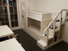 an empty room with white shelves and black flooring