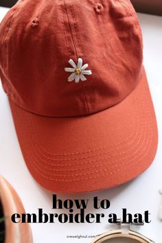 an orange hat with a white daisy on it and the words how to embroider a hat