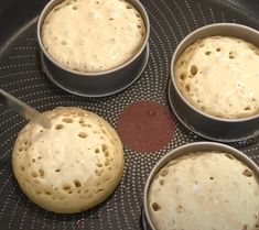 four round pans filled with batter on top of a stove